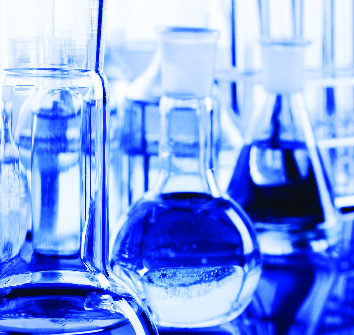 Laboratory glassware containing clear solutions represents biomedical and cell manufacturing research.